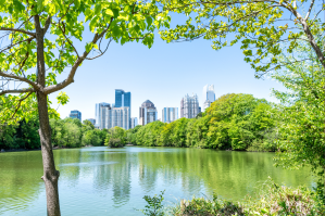 Cityscape, skyline view at Piedmont Park framed by trees overlooking Lake Clara Meer